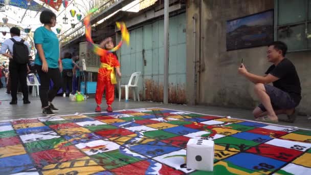 Ein chinesisches Mädchen spielt traditionelles Spiel in der Gasse Mertajam Art Walk. — Stockvideo