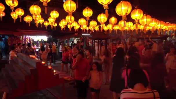 Mensen bezoeken de Chinese tempel tijdens de maanjaarsavond. — Stockvideo