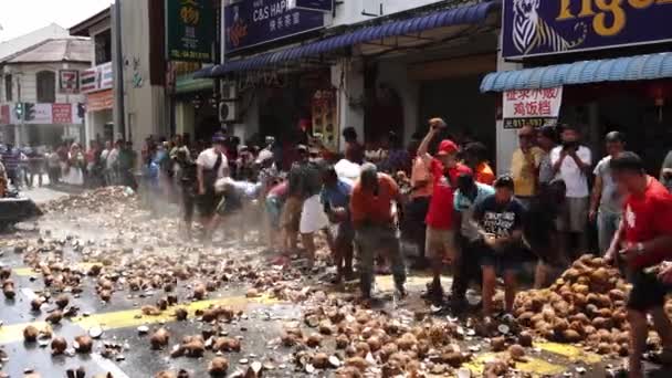 Devotos limpam o caminho esmagando cocos na rua . — Vídeo de Stock