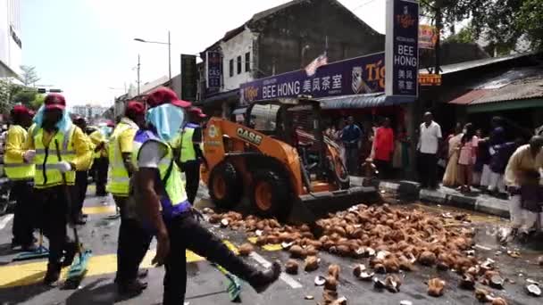 Chargeur à glissière utilisé pour enlever les noix de coco sur le sol pendant Thaipusam — Video