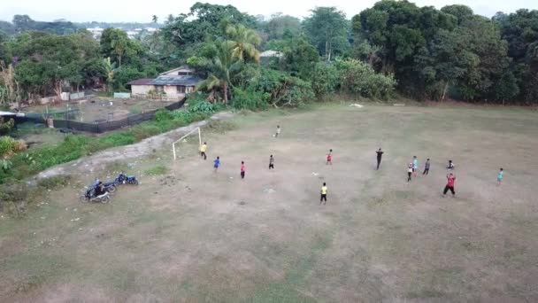 Drone schot lokale kinderen voetballen op het veld. — Stockvideo