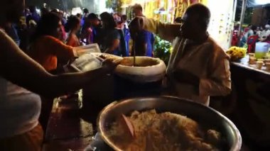 Georgetown, Penang / Malezya - Şubat 07 2020: Gönüllü, Thaipusam Festivali sırasında gece sokakta yiyecek dağıtıyor.