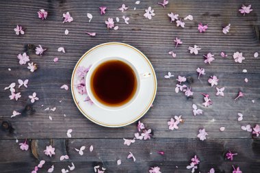 Eflatun çiçekler bir ahşap zemin üzerine çay