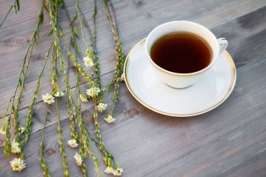 Beyaz çiçekler ile ahşap bir tabloda çay