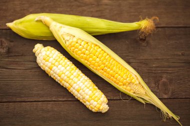 Kırsal ahşap masadaki koçanlarda taze mısır.