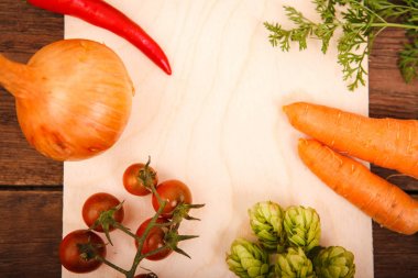 Ahşap arka plan üzerinde bir kesme tahtası üzerinde taze sebze. Chi