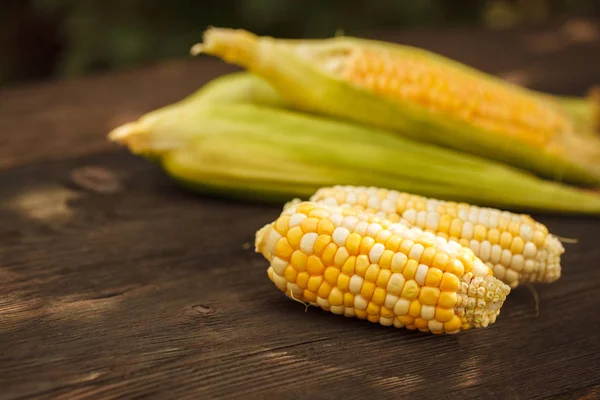 Fresh corn on cobs on rustic wooden table — Stock Photo, Image