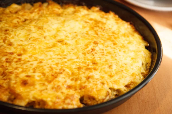 Baked potatoes with cheese in a frying pan. Second course. Close — Stock Photo, Image