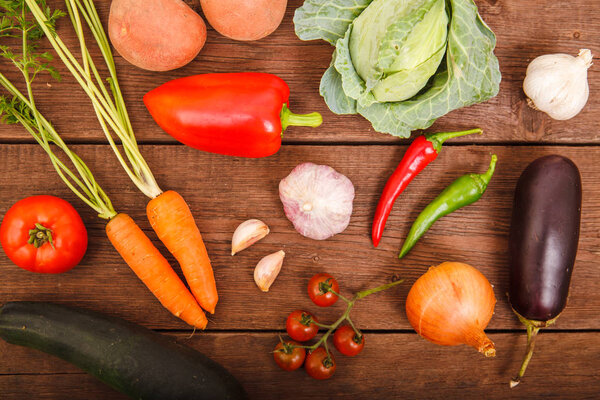 Fresh vegetables on a wooden texture. View from above. Proper nu