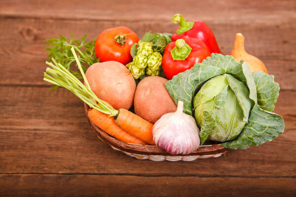 Свежие овощи лежат в корзине на деревянном фоне. Булгари
