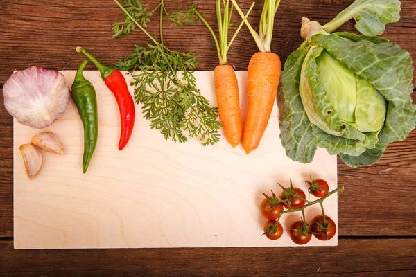 Verduras frescas en una tabla de cortar, sobre un fondo de madera. Chi. — Foto de Stock