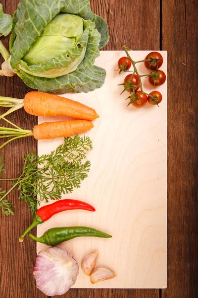 Légumes frais sur une planche à découper, sur un fond en bois. Chi ! — Photo