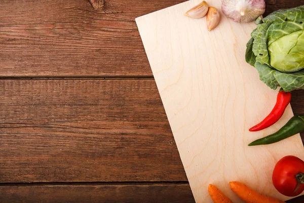 Taze sebze kesme tahtası üzerinde. Lahana, biber, sarımsak, araba