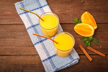 Ahşap arka plan üzerinde bir bardak portakal suyu yenileniyor. Nane,