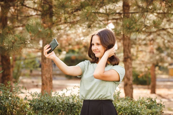 Genç bir kız dışarıda selfie çekiyor..