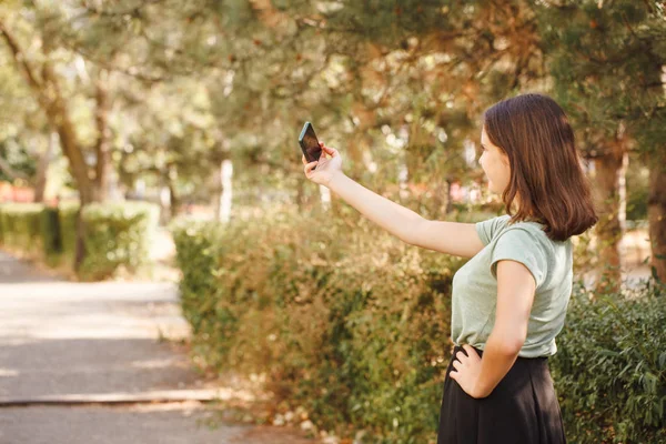 Genç bir kız dışarıda selfie çekiyor..