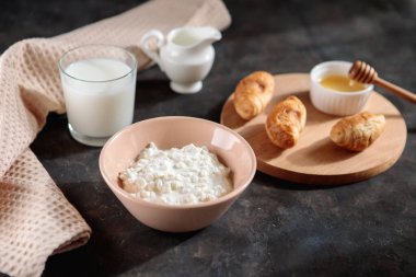 Bir bardak sütlü süzme peynir ve masada ballı kruvasan, mesaj için yer. Lezzetli kahvaltı..