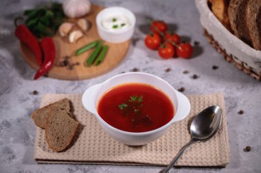 Lezzetli ve doyurucu bir yemek. Masanın yanında sebze, maydanoz, dereotu, yeşil soğan, sarımsak, biber, vişneli domates ve ekmek var..