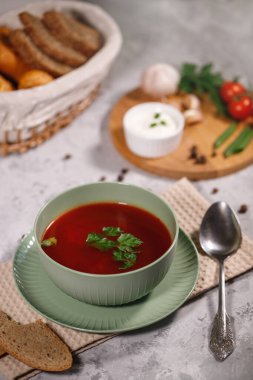 Lezzetli ve doyurucu bir yemek. Masanın yanında sebze, maydanoz, dereotu, yeşil soğan, sarımsak, biber, vişneli domates ve ekmek var..