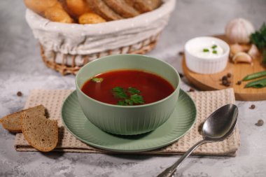 Maydanozlu pancar çorbası, yakın plan. Lezzetli ve doyurucu bir yemek. Gri arka planda sebzeli borç..