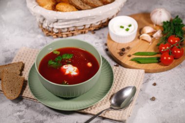 Lezzetli ve doyurucu bir yemek. Masanın yanında sebze, maydanoz, dereotu, yeşil soğan, sarımsak, biber, vişneli domates ve ekmek var..