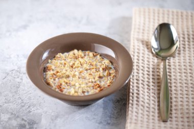 Fırında granola ve süt tabağında. İçinde yoğurt olan müsli. Sağlıklı kahvaltı. Yakın plan..