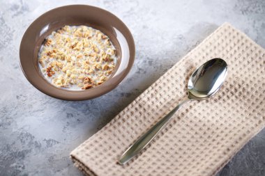 Fırında granola ve süt tabağında. İçinde yoğurt olan müsli. Sağlıklı kahvaltı. Yakın plan..