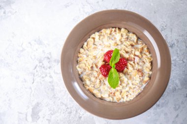 Sağlıklı kahvaltı. Sütlü tahıl gevreği ve nane aromalı ahududu. Lezzetli müsli, yakın plan.