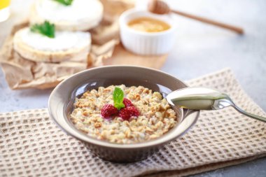 Bir tabakta süt ve ahududu, tam tahıllı ekmek ve taze sıkılmış meyve suyu ile pişirilmiş granola. Sağlıklı ve beslenme amaçlı bir kahvaltı. Nefis müsli..