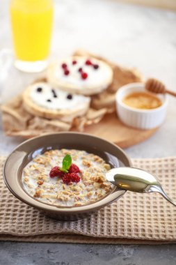 Bir tabakta süt ve ahududu, tam tahıllı ekmek ve taze sıkılmış meyve suyu ile pişirilmiş granola. Sağlıklı ve beslenme amaçlı bir kahvaltı. Nefis müsli.