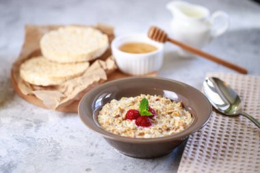 Sağlıklı ve besleyici bir kahvaltı. Bir tabakta süt ve ahududu, tam tahıllı ekmek ve taze sıkılmış meyve suyu ile pişirilmiş granola. Nefis müsli..