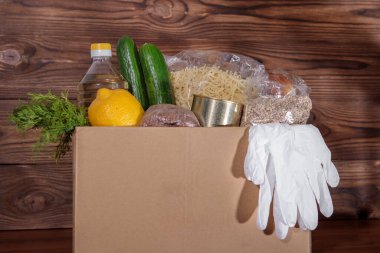 Yemek servisi. Coronavirus gıda bağışı. Eldivenli bir kutuda yiyecek, yakın plan..