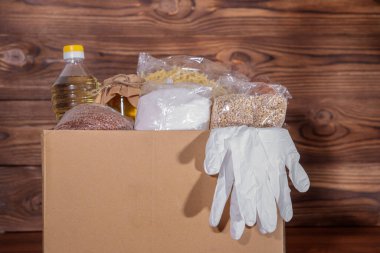 Coronavirus gıda bağışı. Kutuda eldivenli yemek, yakın plan. Yemek teslimatı.