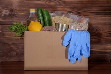 Coronavirus gıda bağışı. Kutuda eldivenli yemek, yakın plan. Yemek teslimatı.