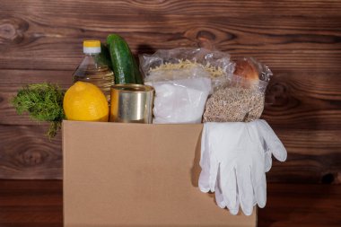 Yemek servisi. Coronavirus gıda bağışı. Eldivenli bir kutuda yiyecek, yakın plan..