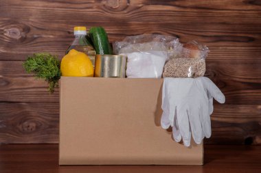 Yemek servisi. Coronavirus gıda bağışı. Eldivenli bir kutuda yiyecek, yakın plan..