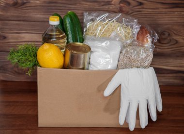 Coronavirus gıda bağışı. Kutuda eldivenli yemek, yakın plan. Yemek teslimatı.