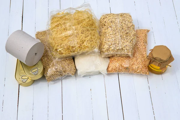 Coronavirus food donation.Cereals, toilet paper, canned food on a white background. Flat lay