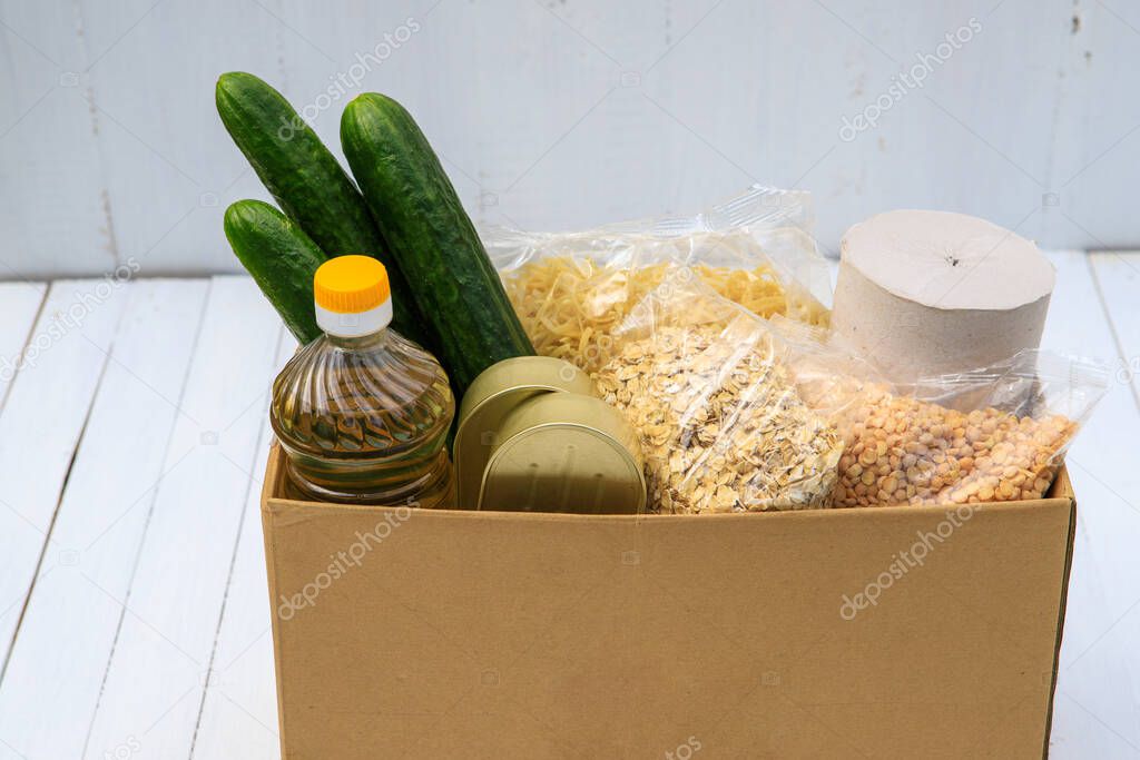 Products in a box for the needy on a white background. Coronavirus donation of food. Food delivery.