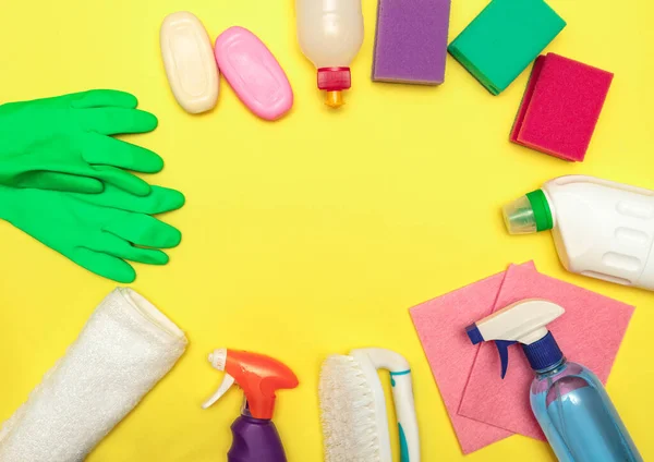 Cleaning and washing products in bottles on a yellow background, space for text. Disinfection. Flat lay