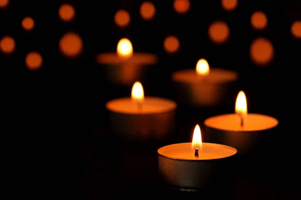 很多蜡烛火焰在黑暗中发光 — 图库照片