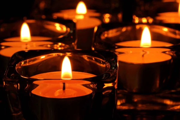 很多蜡烛火焰在黑暗中发光 — 图库照片