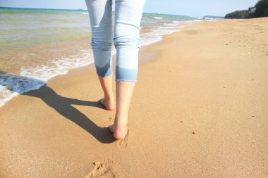 Kumsalda yürüyen bir kadın