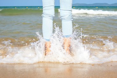 Kumsalda yürüyen bir kadın