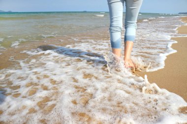 Kumsalda yürüyen bir kadın