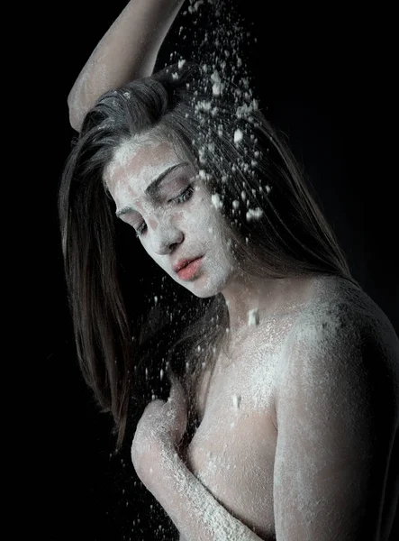 Woman with powder in the studio on a black background Stock Picture