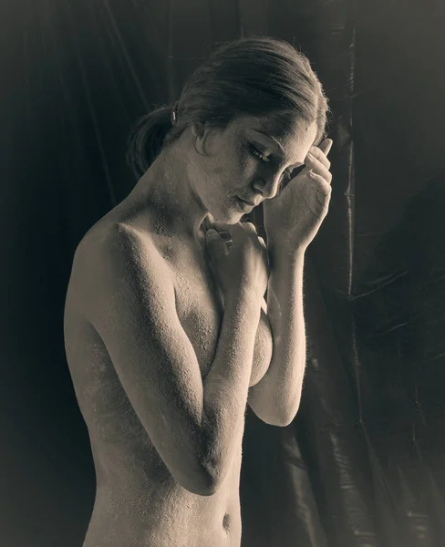 Женщина с порошком в студии на черном фоне — стоковое фото