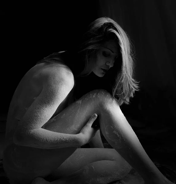 Woman with powder in the studio on a black background — Stock Photo, Image