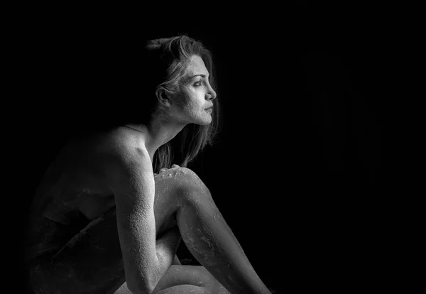 Woman with powder in the studio on a black background — Stock Photo, Image