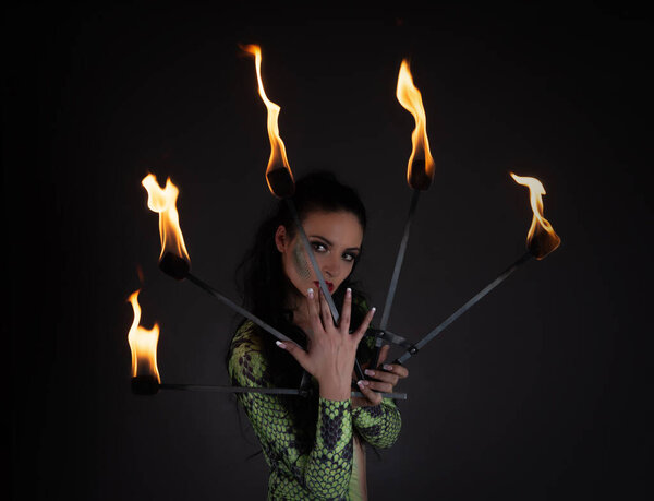 juggler girl performing fire games with python snake dress